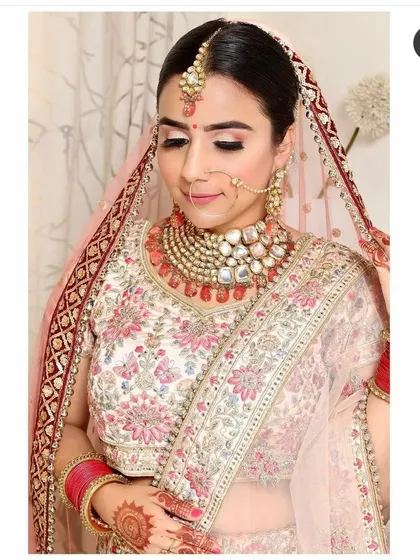 This bride pairs her floral embroidered lehenga with a heavy Polki and Kundan set featuring large uncut stones and red bead drops. A truly magnificent piece available for rent.