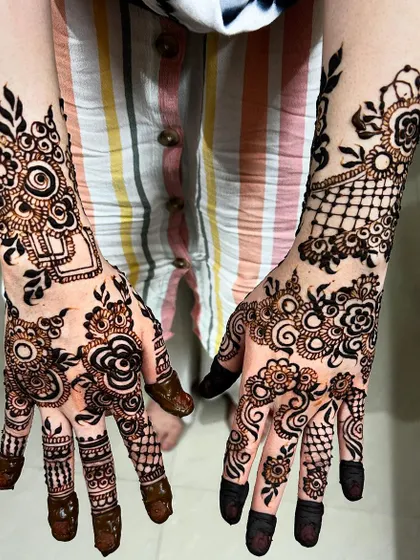 A creative and modern Arabic design that combines florals with geometric netting. The asymmetry between the two hands adds a contemporary and artistic flair.