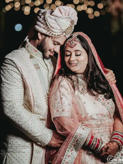 A sweet and gentle portrait of the couple on their wedding night, surrounded by the soft glow of background lights.