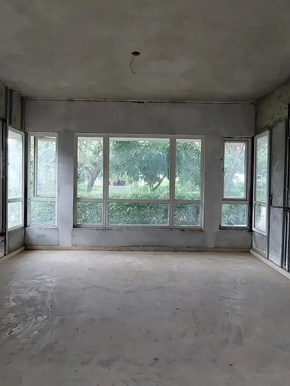 Before: The living room of 'House of Kismish' as a raw, empty shell with concrete walls, holding the potential for a warm and inviting family home.