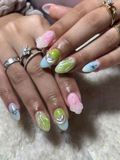 A pastel fantasy set with multi-colored nails, glitter, and 3D elements. This showcases the fun and creative side of nail artistry.
