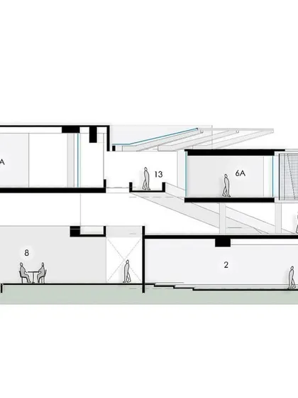 A detailed section of the DRL academic block, showing the integration of classrooms, breakout spaces, and ramps with the sloping landscape.