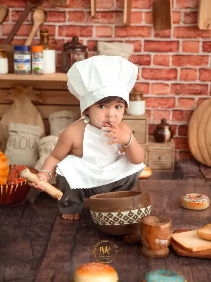 A candid shot of the 'Little Chef' tasting his ingredients while playing with a toy mortar and pestle.