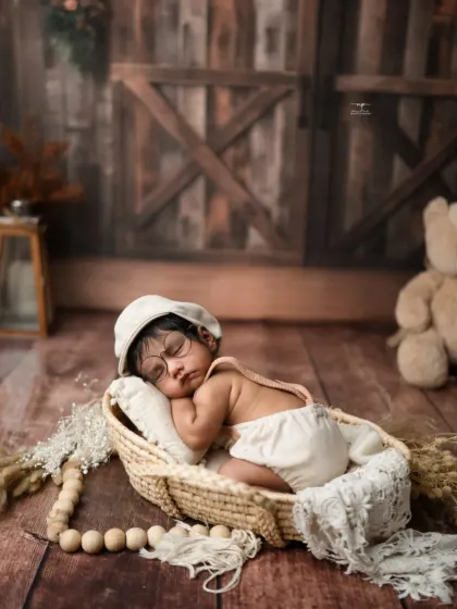 Another sweet pose from our rustic newborn session, with the baby wearing adorable suspenders and a cap.