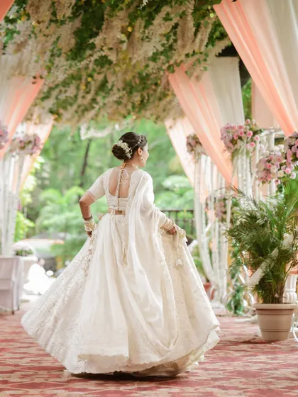 A beautiful shot of the bride from the back, showing off the intricate details of her hairstyle and lehenga as she twirls.