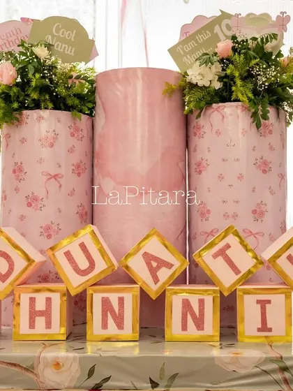 Custom letter blocks spelling out the birthday girl's name, set amongst floral arrangements and themed props.