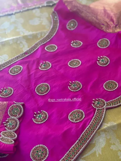 A bright pink blouse with circular kemp stone motifs all over.