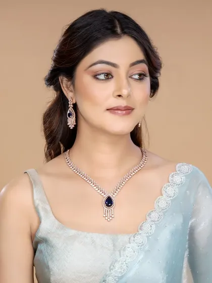 A model showcasing a diamond necklace set with a deep blue sapphire-like stone, conveying a sense of luxury and sophistication.