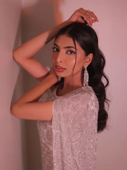The pose in this image highlights the flowing sleeves and intricate details of the white and silver gown.