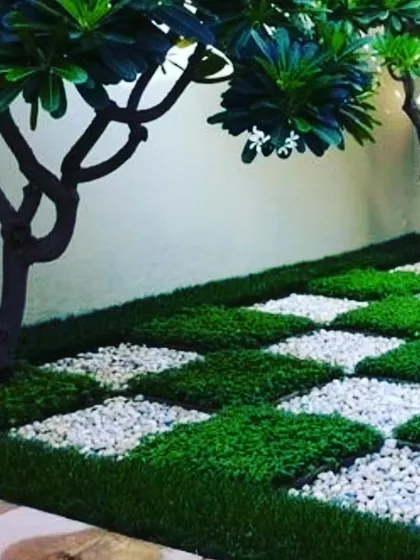 My work isn't just for walls. I design unique groundscapes like this checkerboard pattern using squares of artificial grass and white pebbles, perfect for patios, gardens, and walkways.