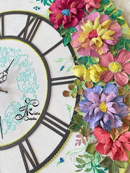 A close-up view of the top floral cluster on the 20-inch clock, highlighting the mix of purple, pink, and yellow flowers.