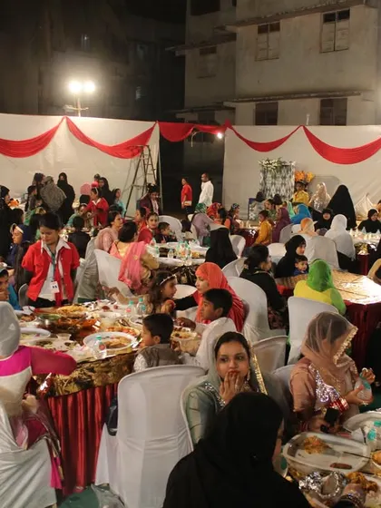 A candid shot of guests, including women and children, enjoying the wedding meal in a comfortable and family-friendly environment.