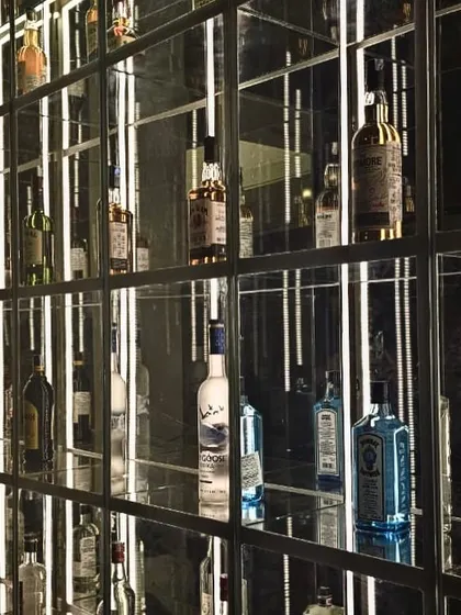 A close-up of the illuminated bar display at "Don't Tell Mama." We used mirrors and integrated LED lighting to create an "infinity" effect, making the liquor collection a dazzling focal point.