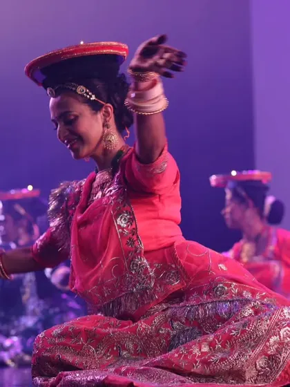 A dynamic shot from a stage show, performing a folk dance with pots. We can incorporate unique props and themes to make your sangeet performance stand out.