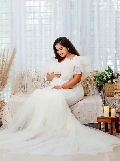 Another angle of the serene, seated portrait. The soft textures and neutral colors of the set make the mother-to-be the true focus.
