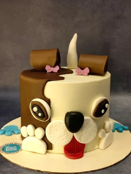 A cute and quirky dog face cake. This design is half chocolate, half vanilla, and is perfect for any dog lover's celebration.