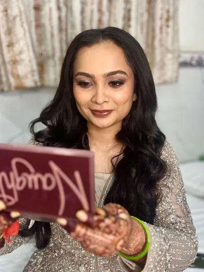 A fun shot of the bride checking her makeup in the mirror.