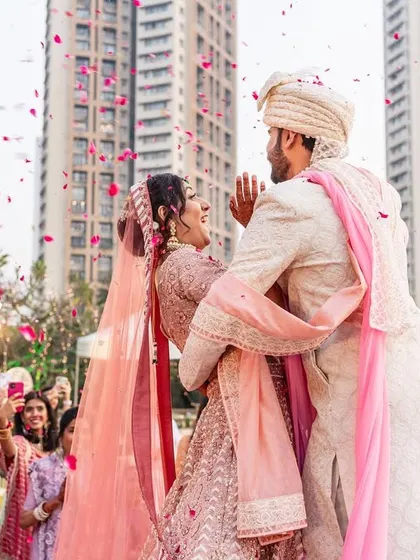 A candid and adorable moment where the bride trips slightly during the varmala, and the groom instantly has her back. It's a sweet glimpse into a future of supporting each other.