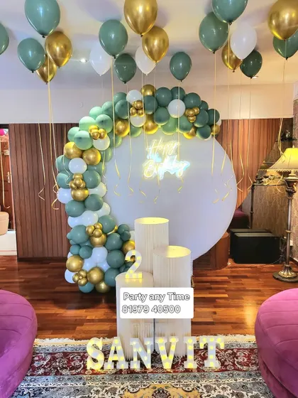 An elegant home decoration with a sage green, white, and gold balloon arch.