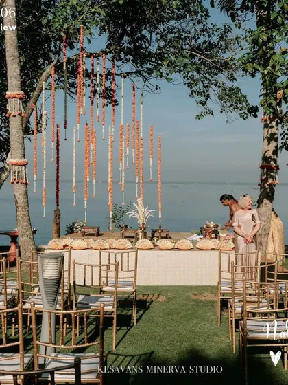 A lakeside wedding setup in the serene Kerala backwaters. The simple decor with marigold streaks allows the stunning natural view to be the main backdrop for the ceremony.