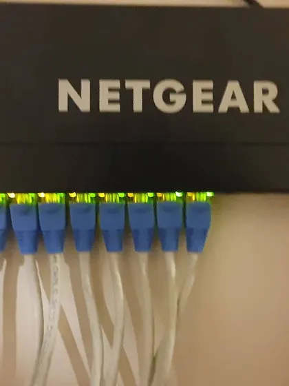 An identical shot showing the blinking lights of an active Netgear network switch. This is the heart of the IP camera system, connecting everything together.