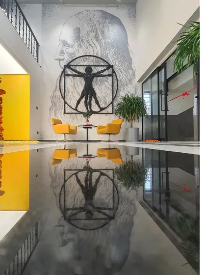 A stunning reflection shot of the Da Vinci mural and Vitruvian Man sculpture at the Centrix office. The glossy floor doubles the impact of the artwork.