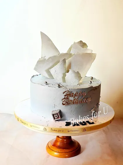 This modern birthday cake is a whole wheat date and walnut cake. I gave it a contemporary look with a grey buttercream finish and abstract white chocolate shards.