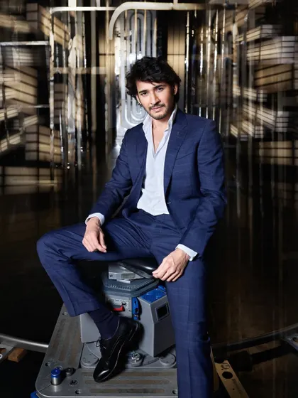 Mr. Cool. This is a behind the scenes shot of Mahesh Babu, but he makes everything look effortless. The simple suit and the industrial set create a great contrast, highlighting his suave and composed presence.