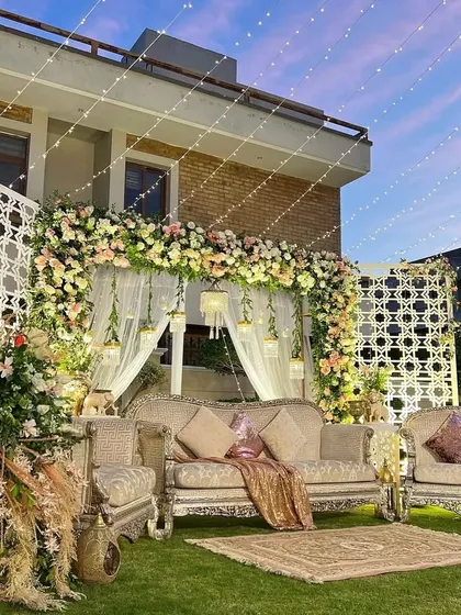 A closer look at the elegant outdoor stage from image 74. The pastel floral arrangements and classic furniture create a sophisticated and romantic vibe.