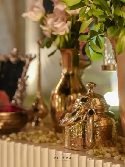 A wider shot of the console table, showing how the collection of vintage brass items, florals, and candles comes together to create an elegant and welcoming display.