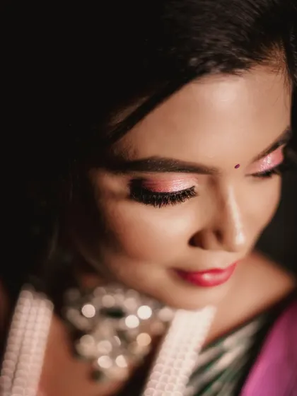 A close-up on the eye makeup, showing a shimmery pink eyeshadow look that makes her eyes pop.