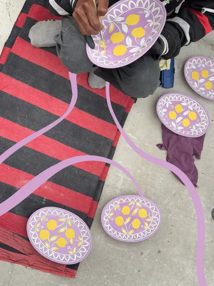 Watching an artist paint beautiful plates, with a purple doodle connecting them all.