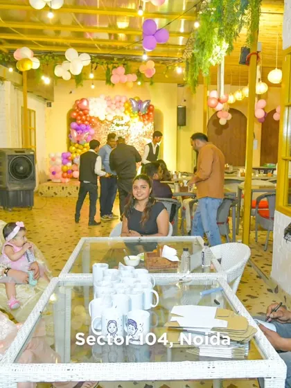 A wide shot of our dining area during a party, showing families enjoying their meals in a festive, decorated setting.
