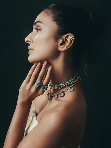 A side profile showcasing the art of the stack. Here, layered necklaces, multiple rings, and delicate ear cuffs from our Antara X Jet Gems collection create a look that is both bold and beautifully detailed.