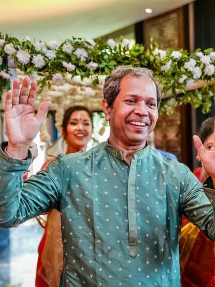 The father of the bride dances with joy during his daughter's wedding procession, a beautiful, unscripted moment of happiness.