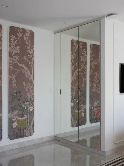 Another view of the parent's bedroom, showing the custom wallpapered wardrobe with mirrored panels. This design choice adds depth and reflects light, making the space feel larger and more elegant.