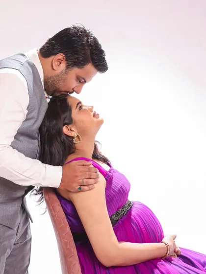 A tender kiss for the glowing mom-to-be. This studio maternity shoot captures a beautiful, intimate moment between the couple.