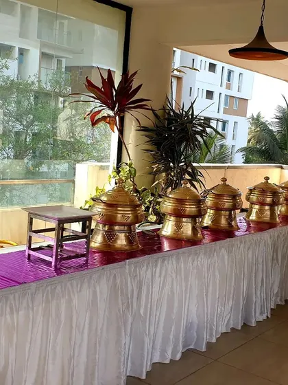 A similar view of the balcony buffet setup, highlighting the neat arrangement of the chafing dishes on a table with clean white skirting and a vibrant pink runner.