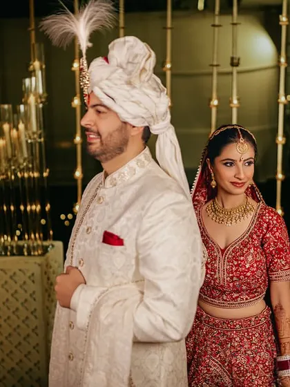 A candid shot of the couple, framed by the warm glow of diyas, creating an intimate and traditional feel.