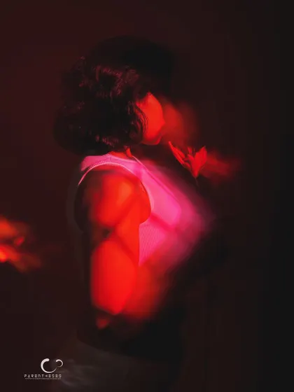 A profile view in a sea of red light and motion. This abstract portrait focuses on silhouette and color to evoke a powerful, emotional response.