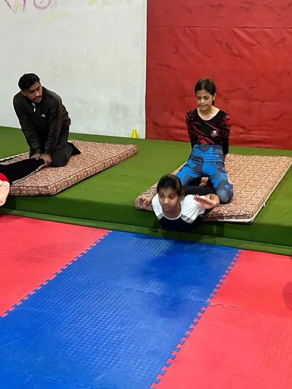 Partner-assisted stretching helps my athletes achieve deeper flexibility safely. Here, I am helping young gymnasts with their back flexibility in a prone position.