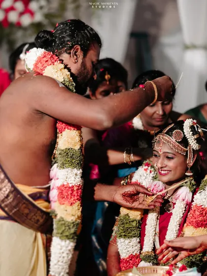 A key moment in the wedding ceremony, captured with a focus on the couple's interaction and the bride's happy smile.