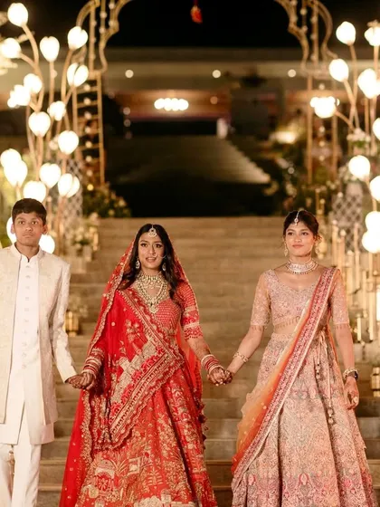 The bride walks down the steps, her path lit by glowing floral lamps.