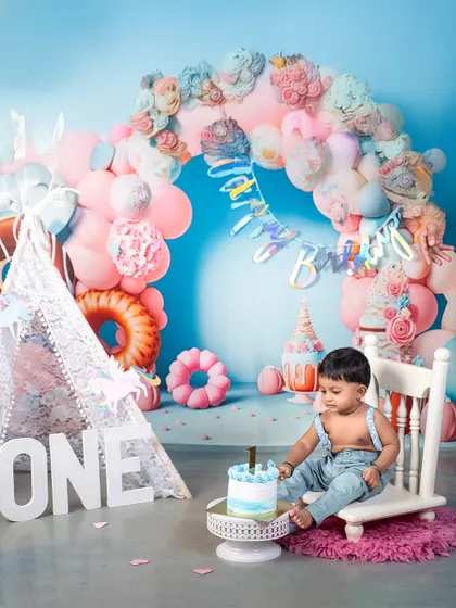 A moment of quiet contemplation before the cake smash begins. This little boy is taking in his beautiful first birthday setup, complete with a blue ombre cake and pastel decorations.