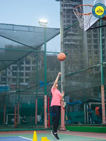 A young girl practices her shooting form. I provide personalized coaching to help every player, no matter their age, improve their technique.