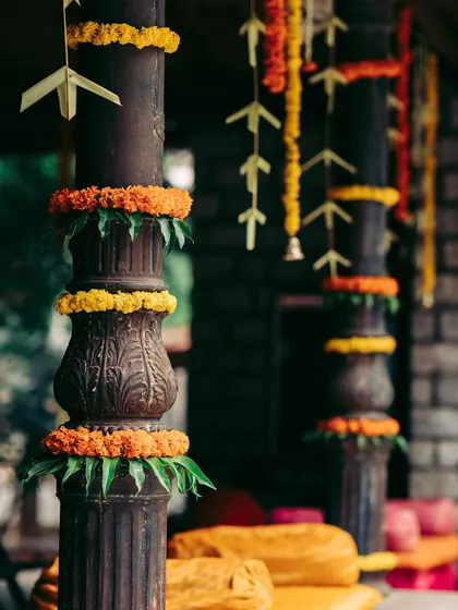 Traditional pillars decorated with marigold garlands and mango leaves, adding a classic and auspicious touch to the venue.