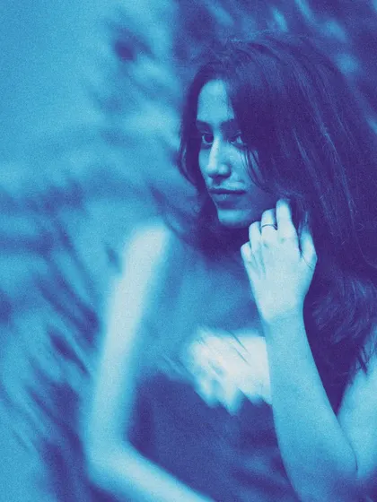 A profile view with the same blue, blurry aesthetic. This technique can create a dreamy or mysterious vibe, showing a model's versatility in different creative concepts.