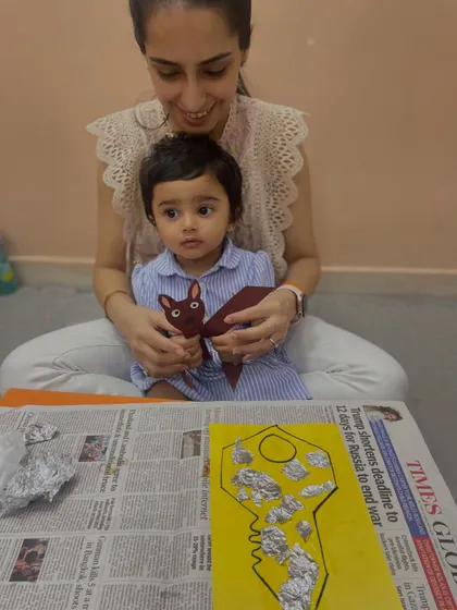 A mother and daughter create a key-themed craft using aluminum foil, exploring different textures and materials.