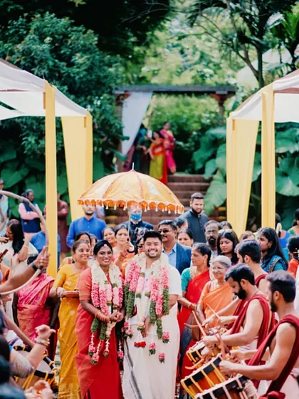 The grand entrance of the bride and groom. Her makeup is designed to be impactful from a distance and picture-perfect up close, ensuring she is the center of attention.