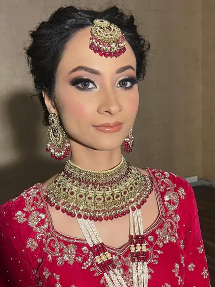 A beautiful portrait of the bride looking directly at the camera. Her eyes are mesmerizing with the dramatic makeup, balanced by flawless skin and a soft lip color.
